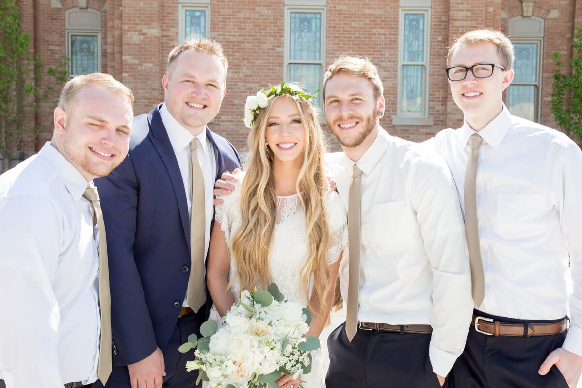 a bride and four brothers smiling