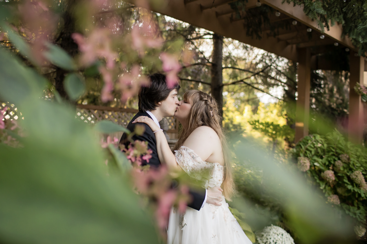 summit hill studios bride groom kissing in background with trees