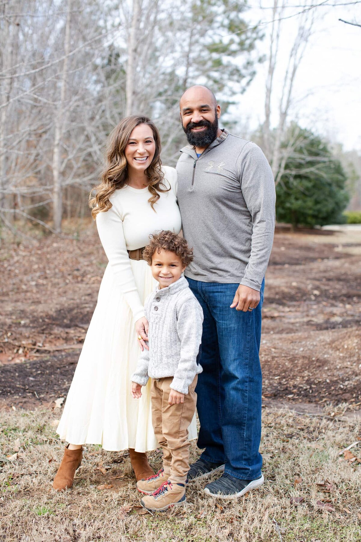 family of three posing for a photo in Wake Forest, NC. Winter family portraits in Wake Forest.