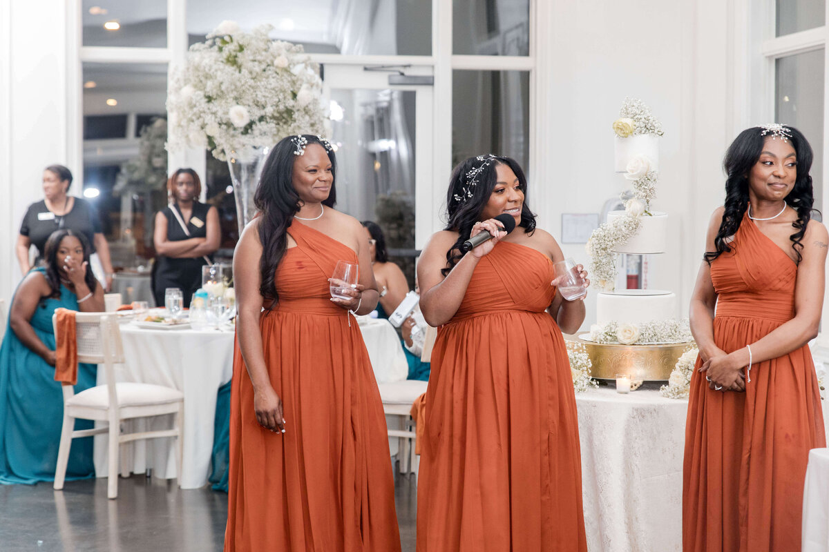The bride stands surrounded by her bridesmaids, all sharing a joyful and elegant moment.