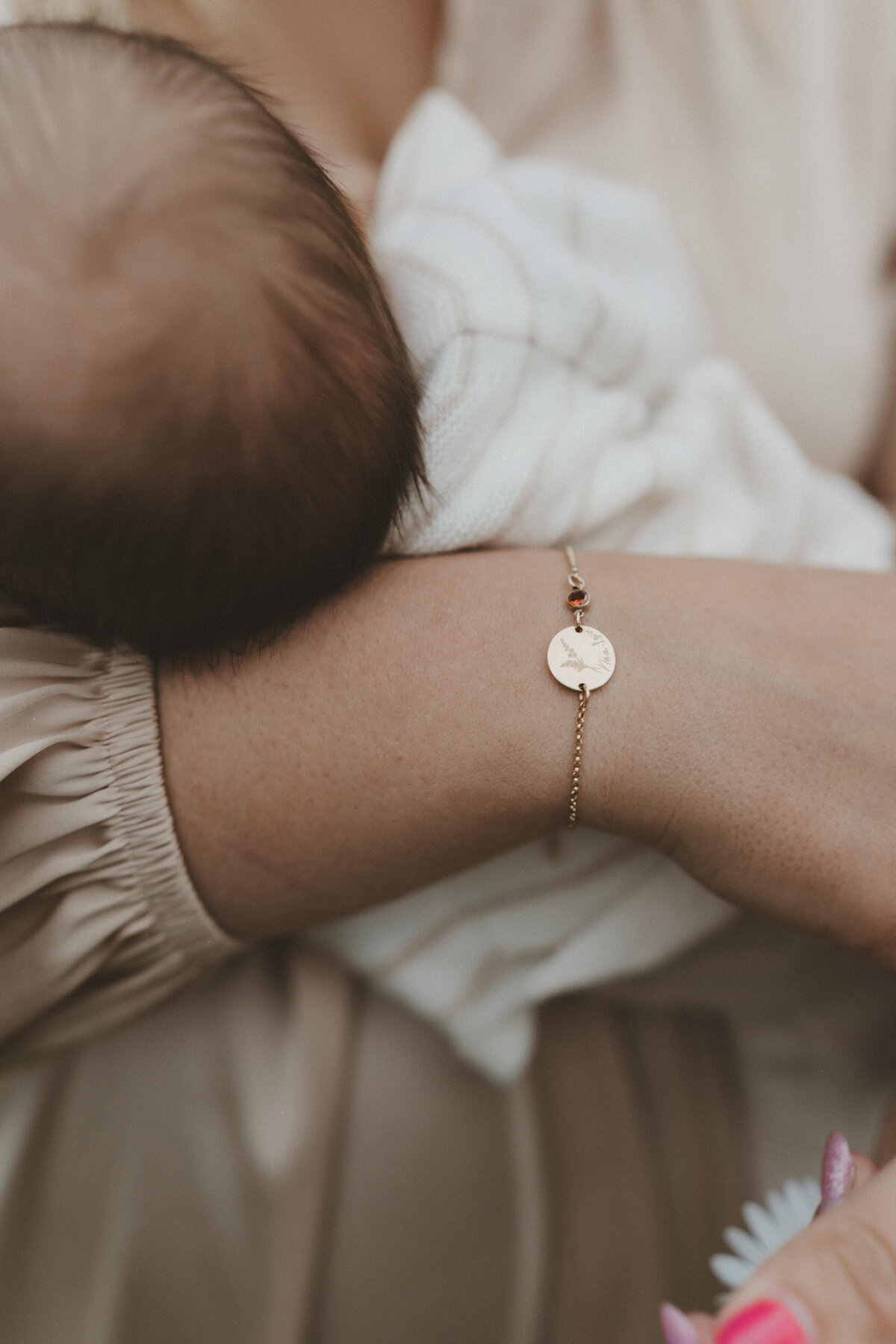Detailfoto van hand van een moeder bij haar baby met armbandje.