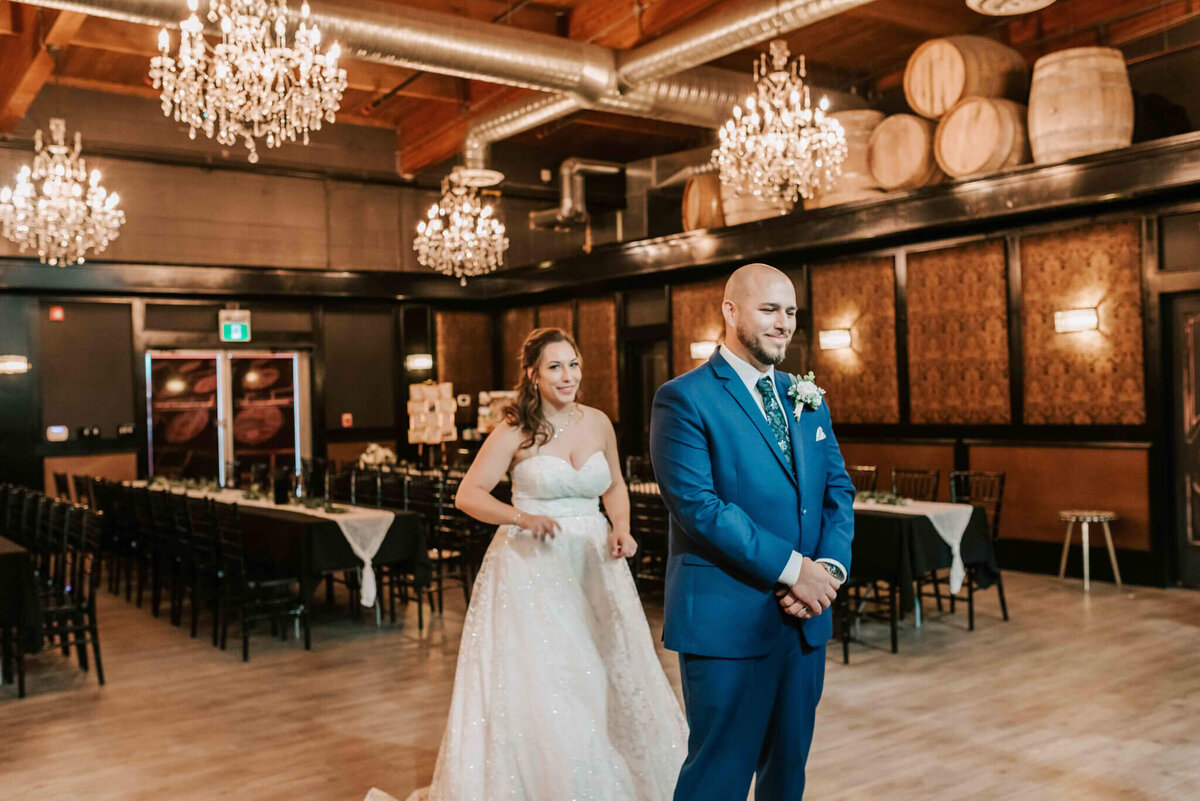 Bride standing behind the groom at the first look. 