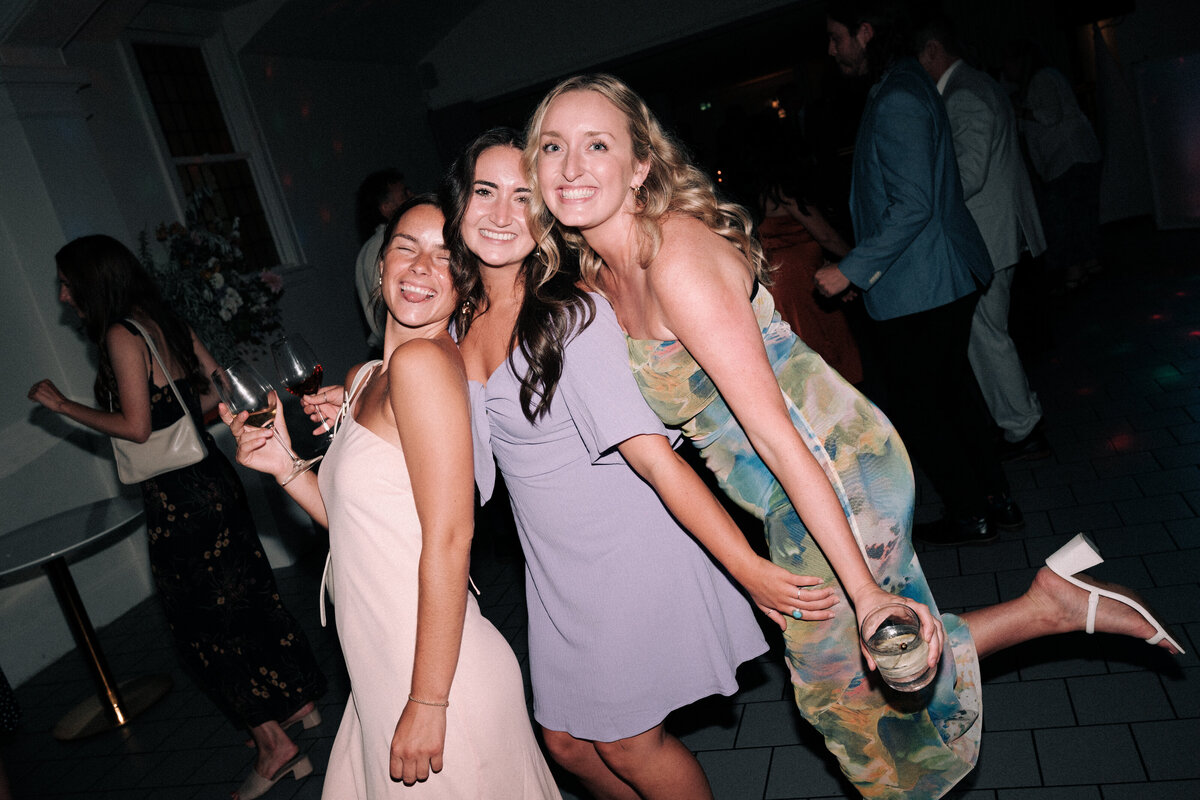 friends with drinks smiling  with eachother during late-night dancing