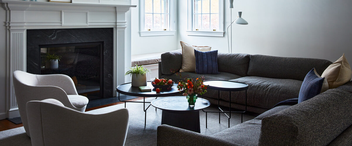 A historic Boston home’s family room blends classic white millwork with modern furniture, creating a timeless yet contemporary space.