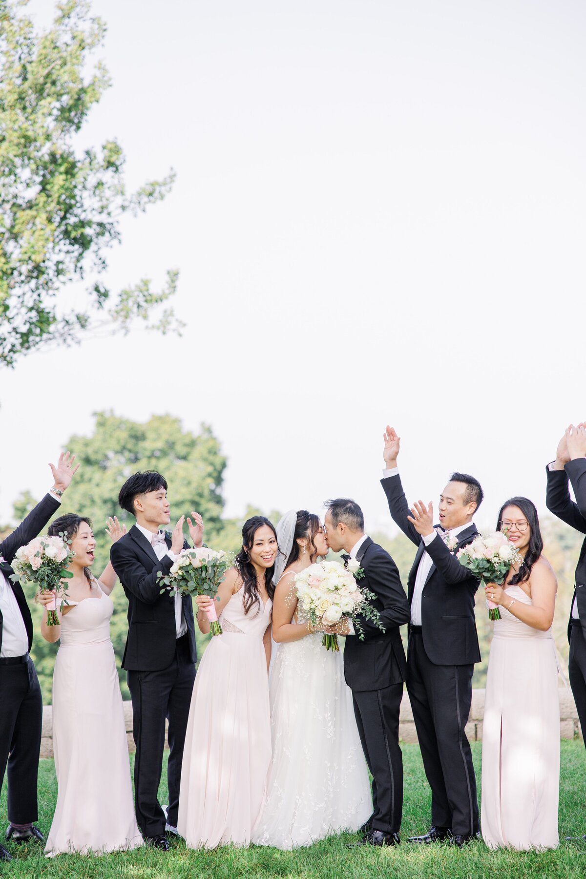 Wedding party cheering as the bride and groom kiss during Boston wedding pictures