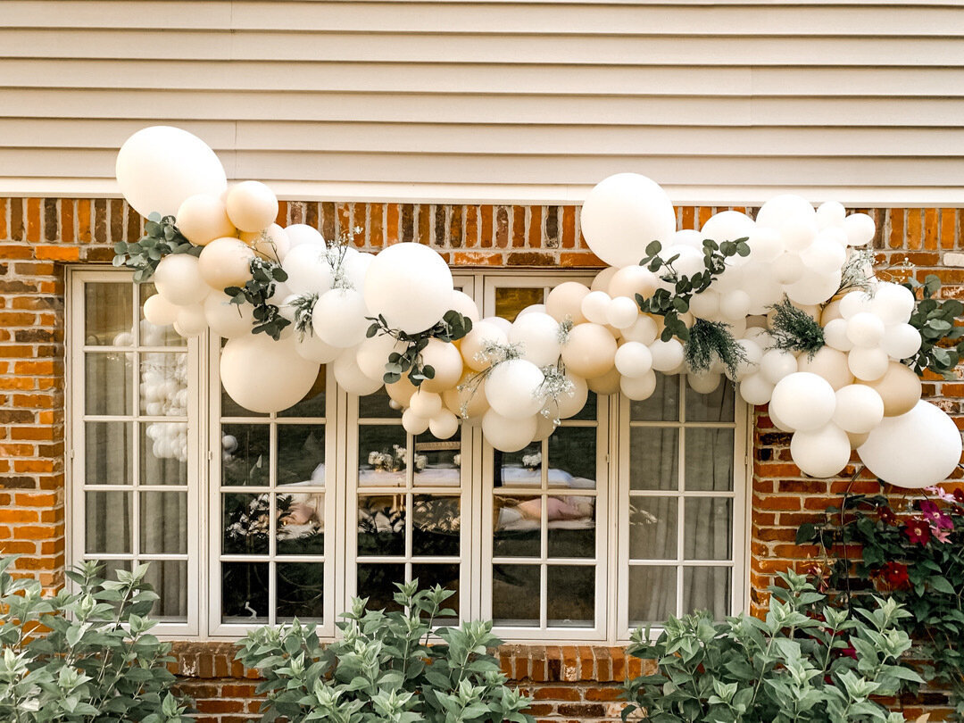 outdoor white balloon arch above windows for girls night