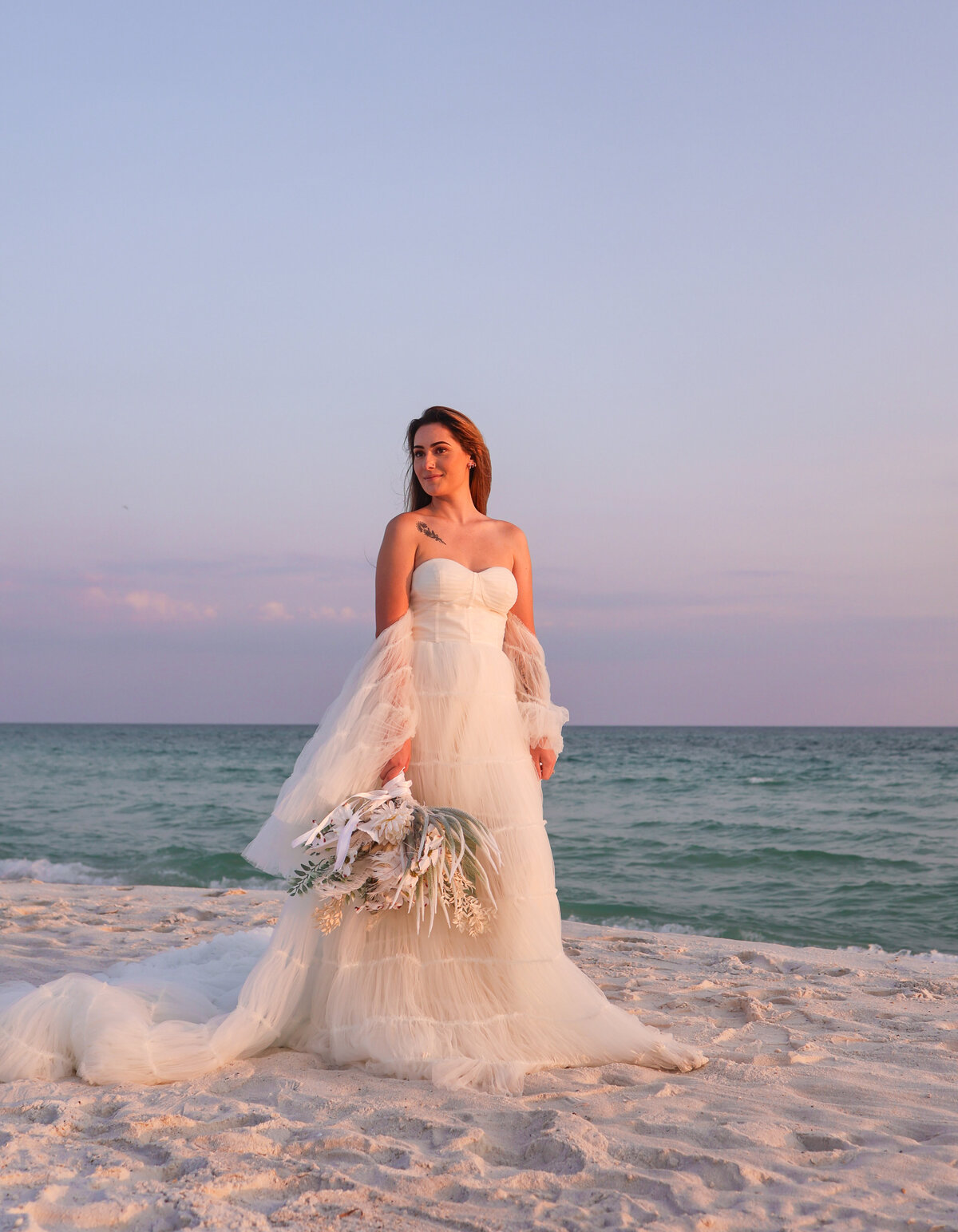 bride holding her floral bouquet at sunset in panama city beach  florida by elopement photographer Amanda Richardson Photography