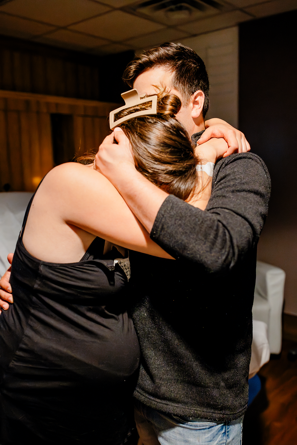 A husband cradles his wife as she experiences difficult contractions