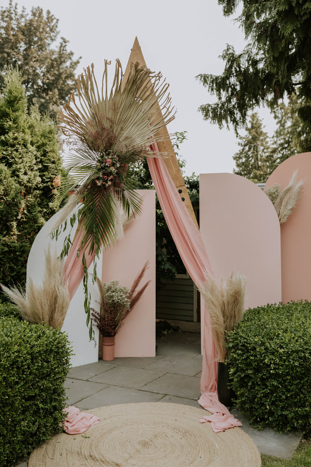 Boho inspired ceremony backdrop with pampas, and florals by J.A.M Florals, contemporary and playful Kelowna wedding florist, featured on the Brontë Bride Vendor Guide.