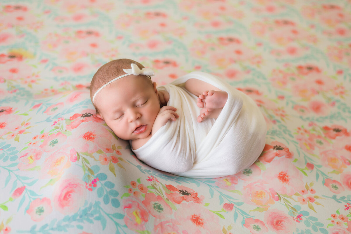Newborn Photographer, a baby girls sleeps on floral sheets