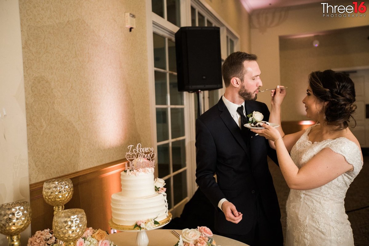 Bride feeds wedding cake to her Groom