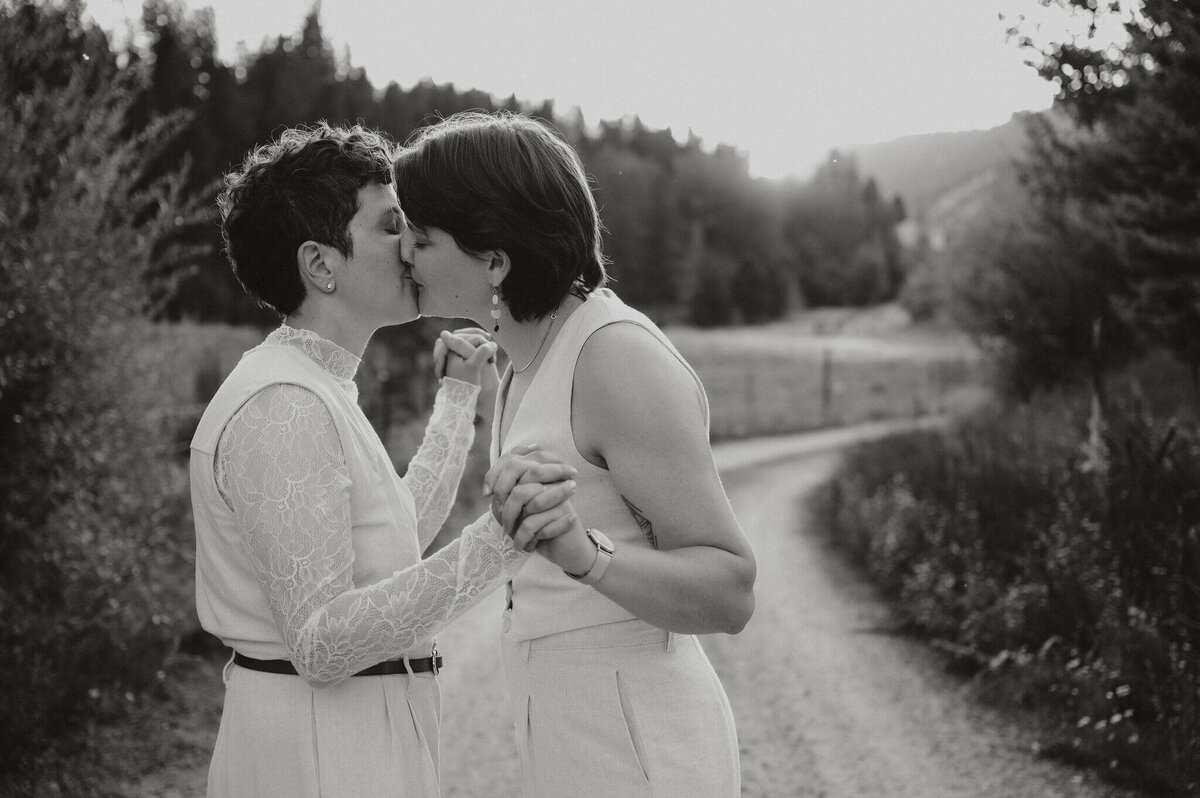 Wedding couple kissing on a dirt road.