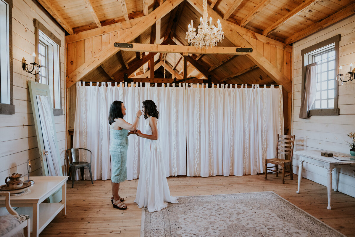 Mother of the Bride helps bride get ready for her big day in the barn style bridal suite.