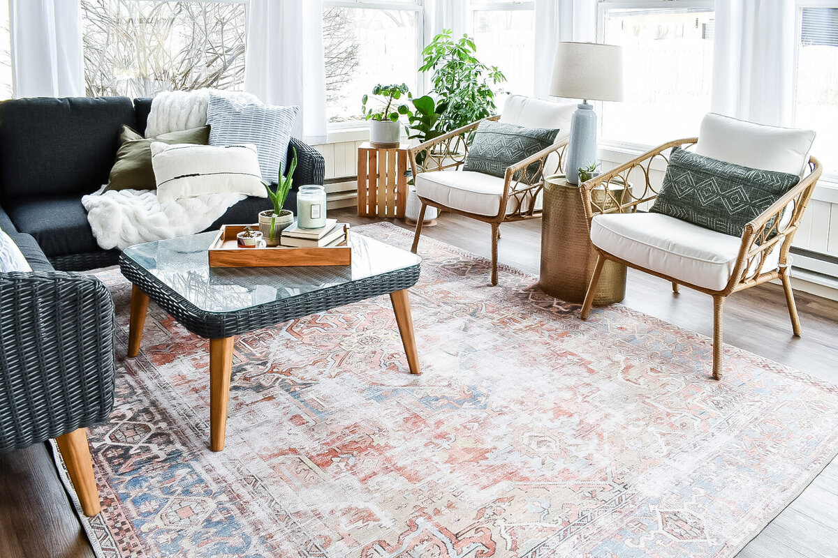 A large patterned boho rug sits in a four seasons room