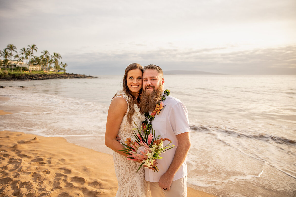 Maui Wedding Photographer captures bride and groom embracing on beach after Maui beach wedding