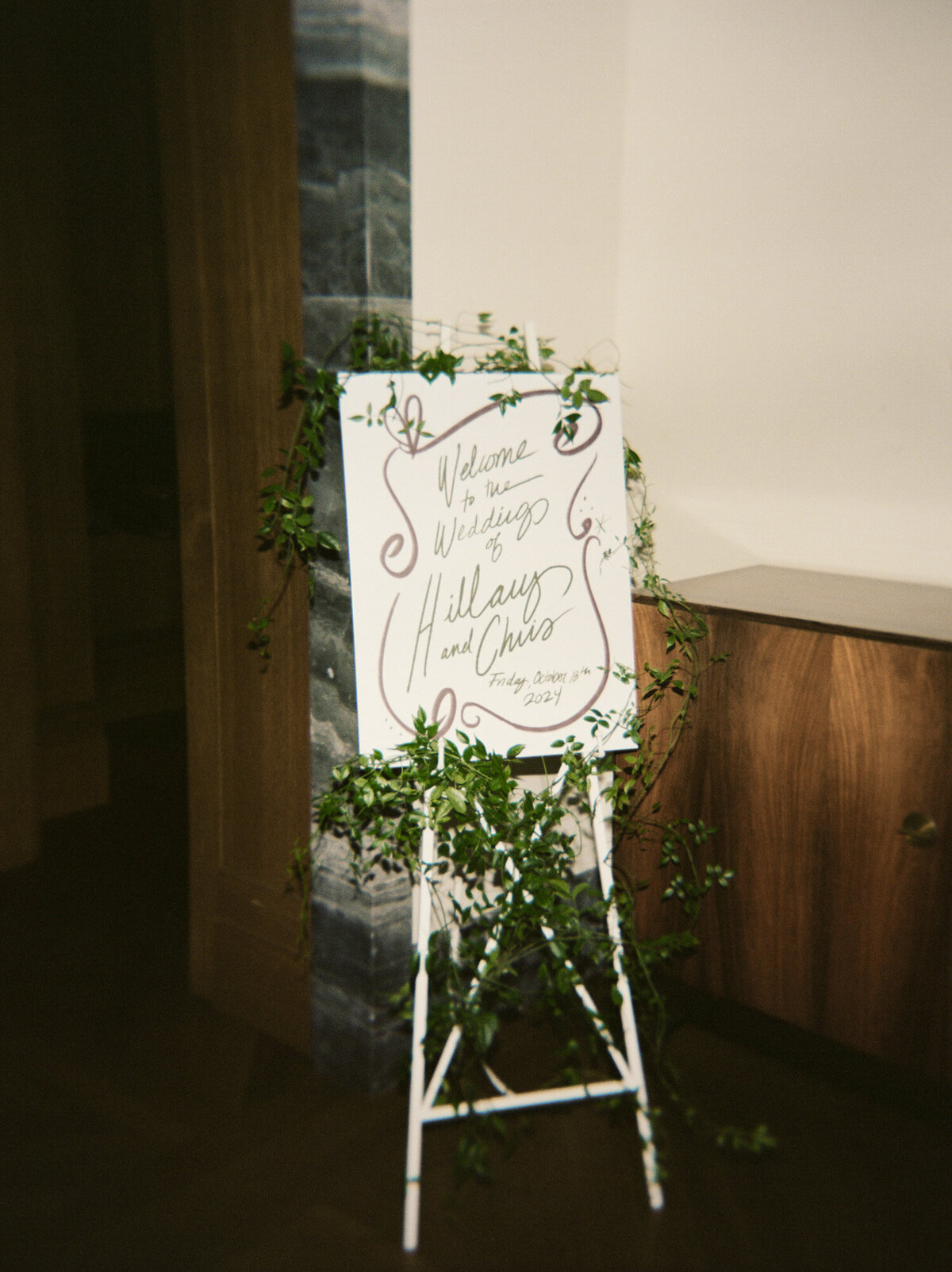 wedding sign laden with greenery vines captured at Shinola Hotel by photographer Christina Harrison