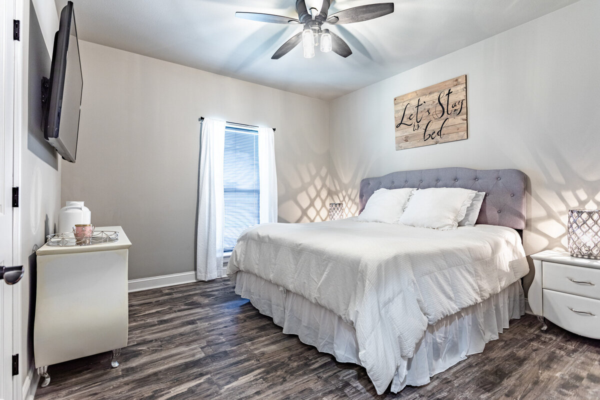 Bedroom with luxurious bedding and smart TV in this five-bedroom, 3-bathroom vacation rental house for up to 10 guests with free wifi, private parking, outdoor games and seating, and bbq grill on 2 acres of land near Waco, TX.