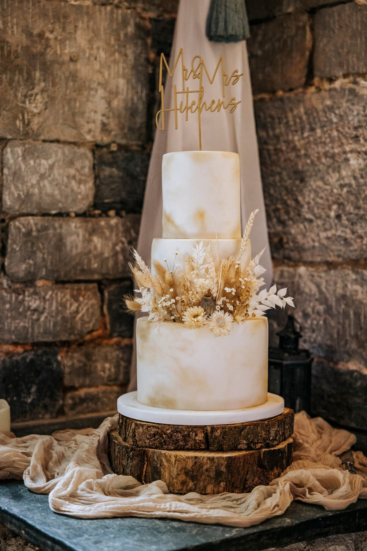 The top of a wedding cake the a sign that says Mr & Mrs Hitchins