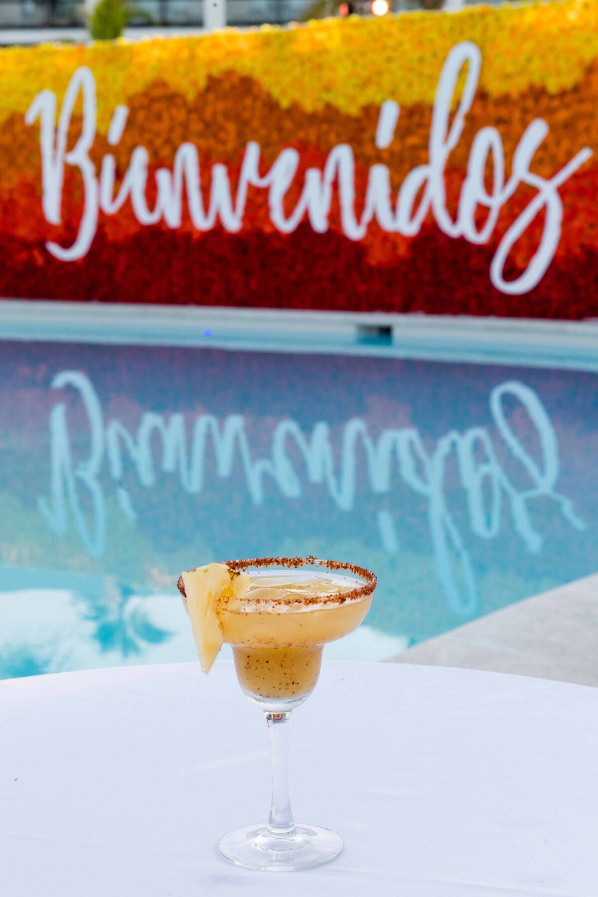 A special margarita with Bienvenidos  poolside decoration in background