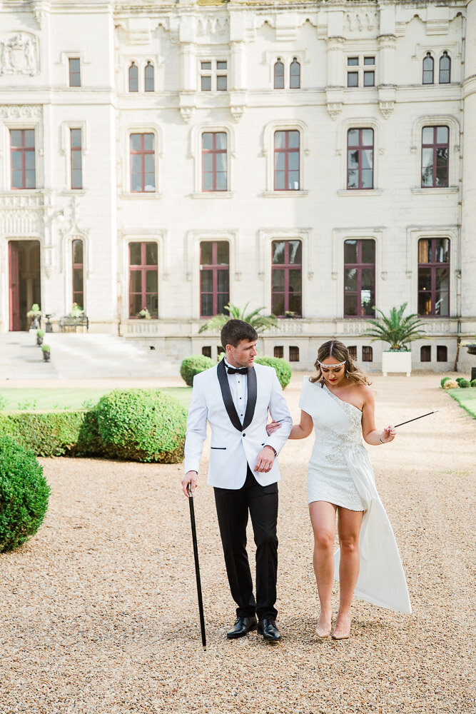 Bride and groom walking on the grounds of Château Challain in a stylish, fashion-inspired pose, captured in elegant, natural wedding photography.