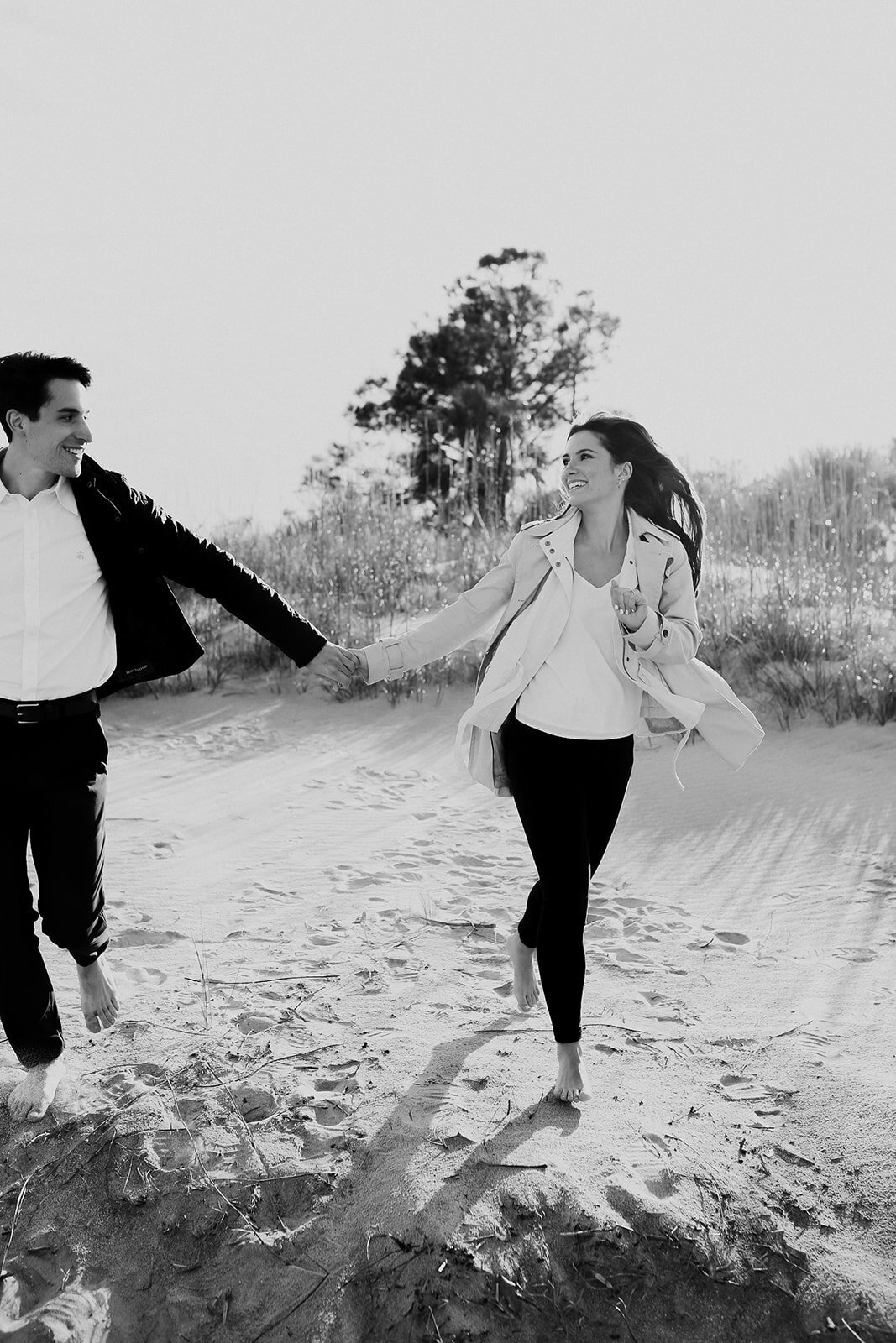 Couple running on sand and looks at each other