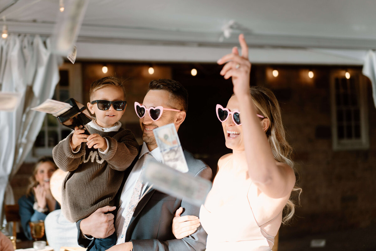bride and groom with young boy all wearing heart shaped glasses