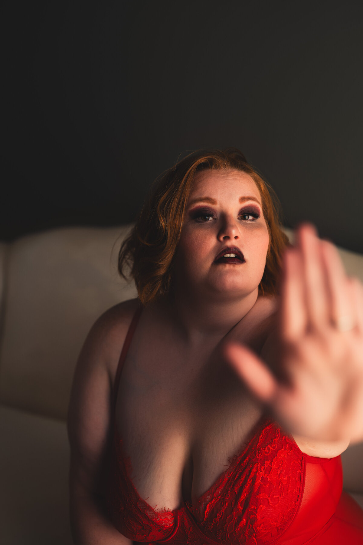 Girl in red lingerie with her hand up for her Nashville boudoir session
