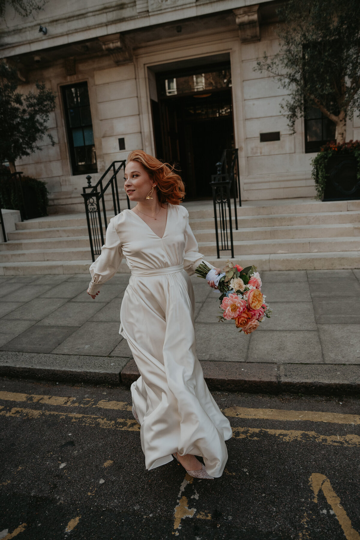 A bride runs across the street outside Shoreditch Town Hall Hotel in London. 