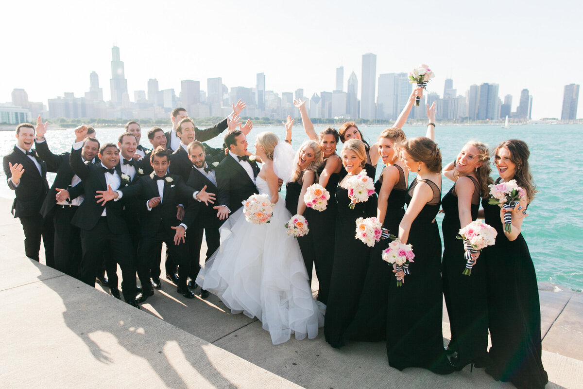 Wedding party cheers the newlyweds in front of the Chicago skyline