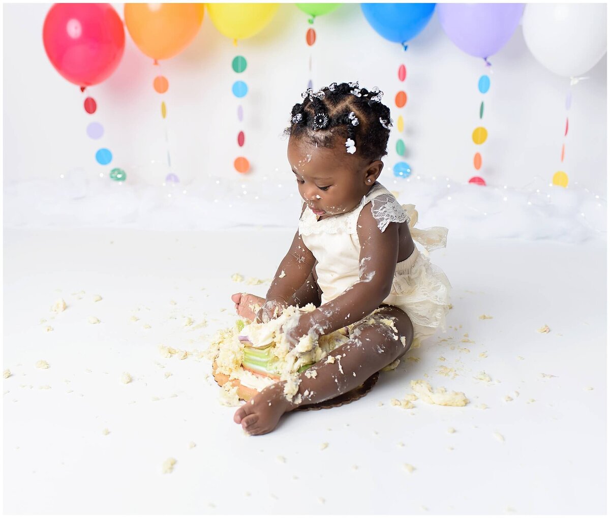 A girl's cake smash session, capturing her playful and carefree spirit as she dives into a cake.