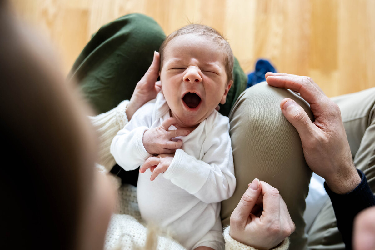 Baby on mom and dad's laps yawning