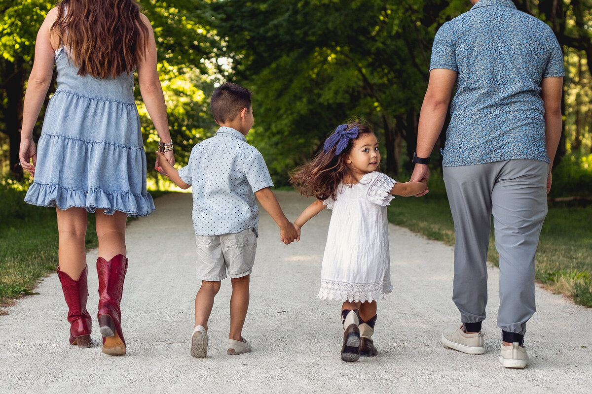 Family holding hands at a sunset photoshoot.