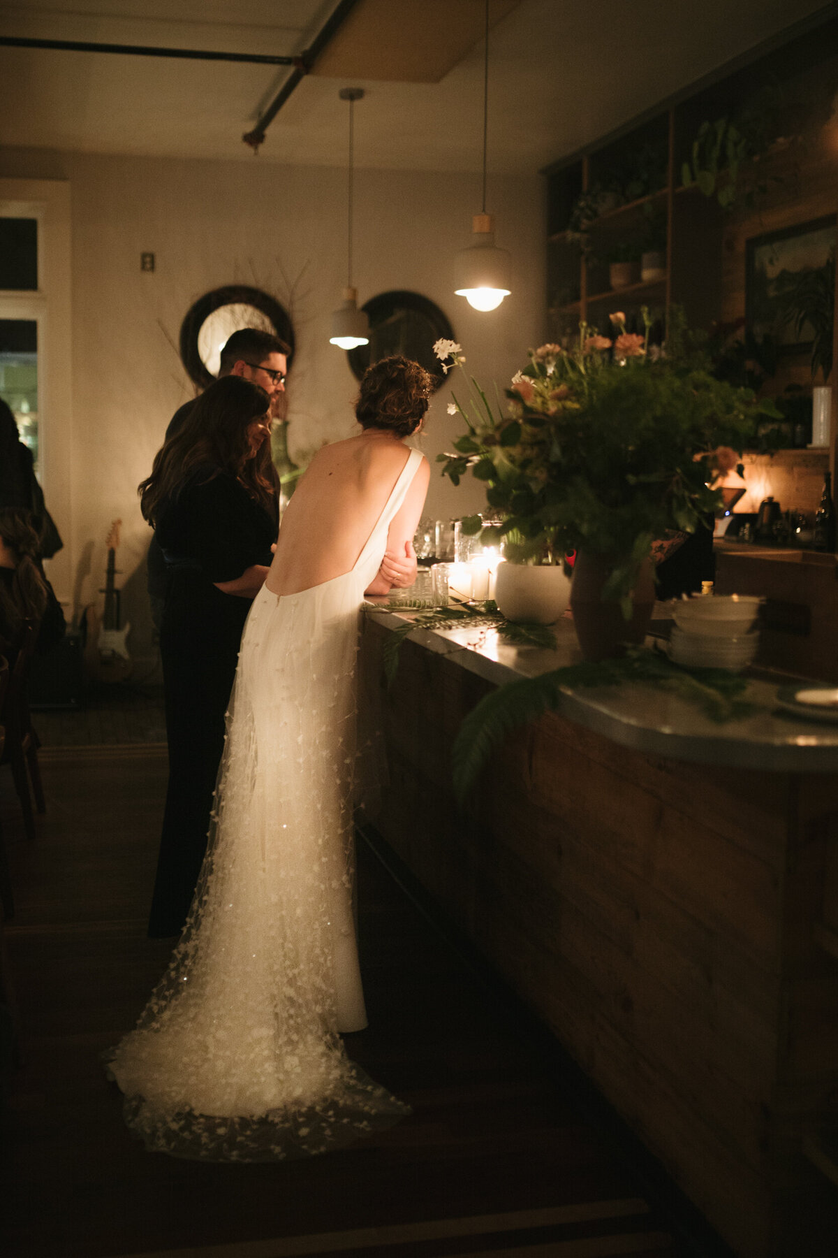 Bride stands at the bar in her gorgeous wedding gown at her intimate celebration in Portland Oregon.