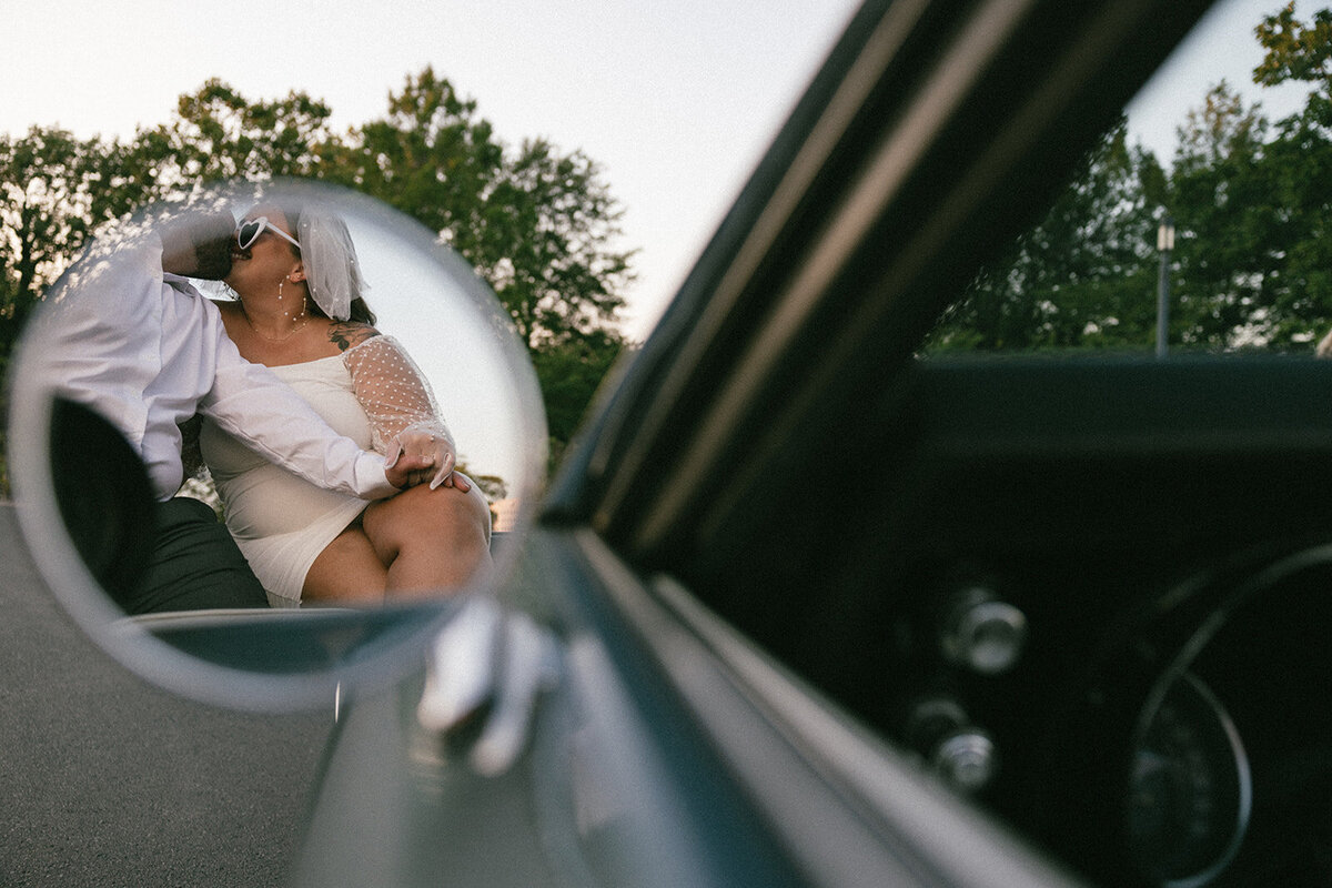Wedding couple shares a romantic kiss on the back of a Firebird parked at The Parthenon in Nashville, TN. 