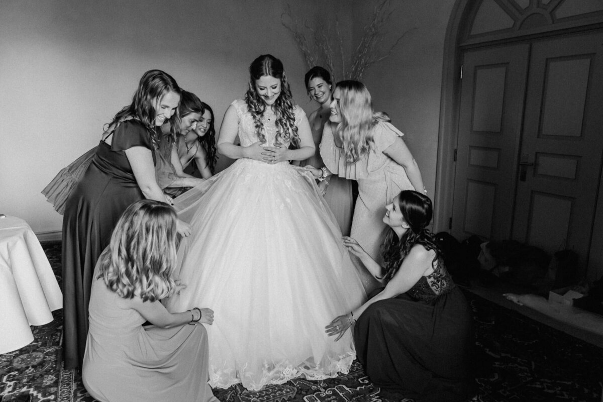 Die Braut wird von ihren Brautjungfern liebevoll vorbereitet. Ein berührender Moment des "Getting Ready" im Schloss Rapperswil. Authentische und ungestellte Hochzeitsfotografie von Jane, die intime Augenblicke festhält.