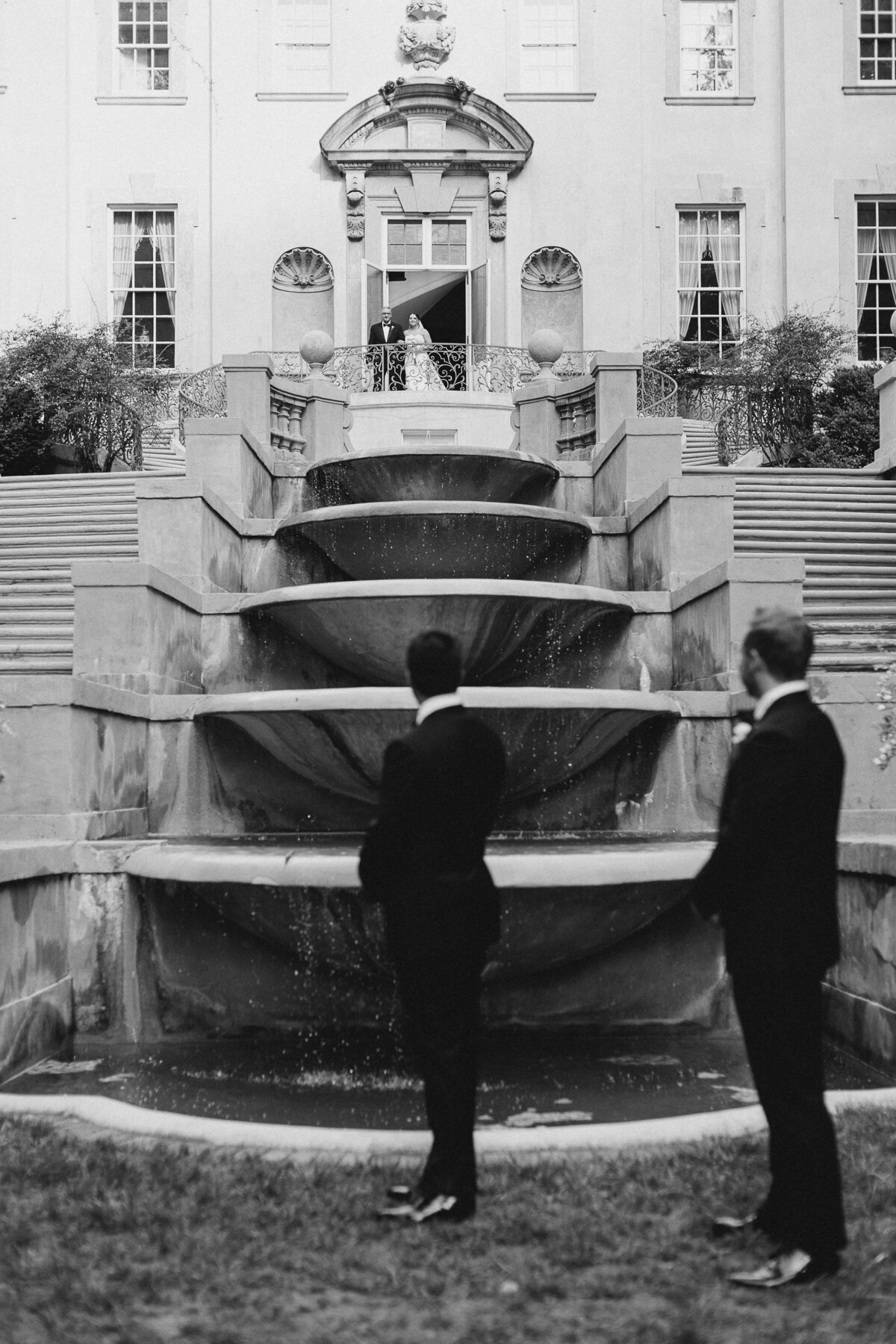 Groom looking up the stairs at the Swan House in Atlanta at his bride