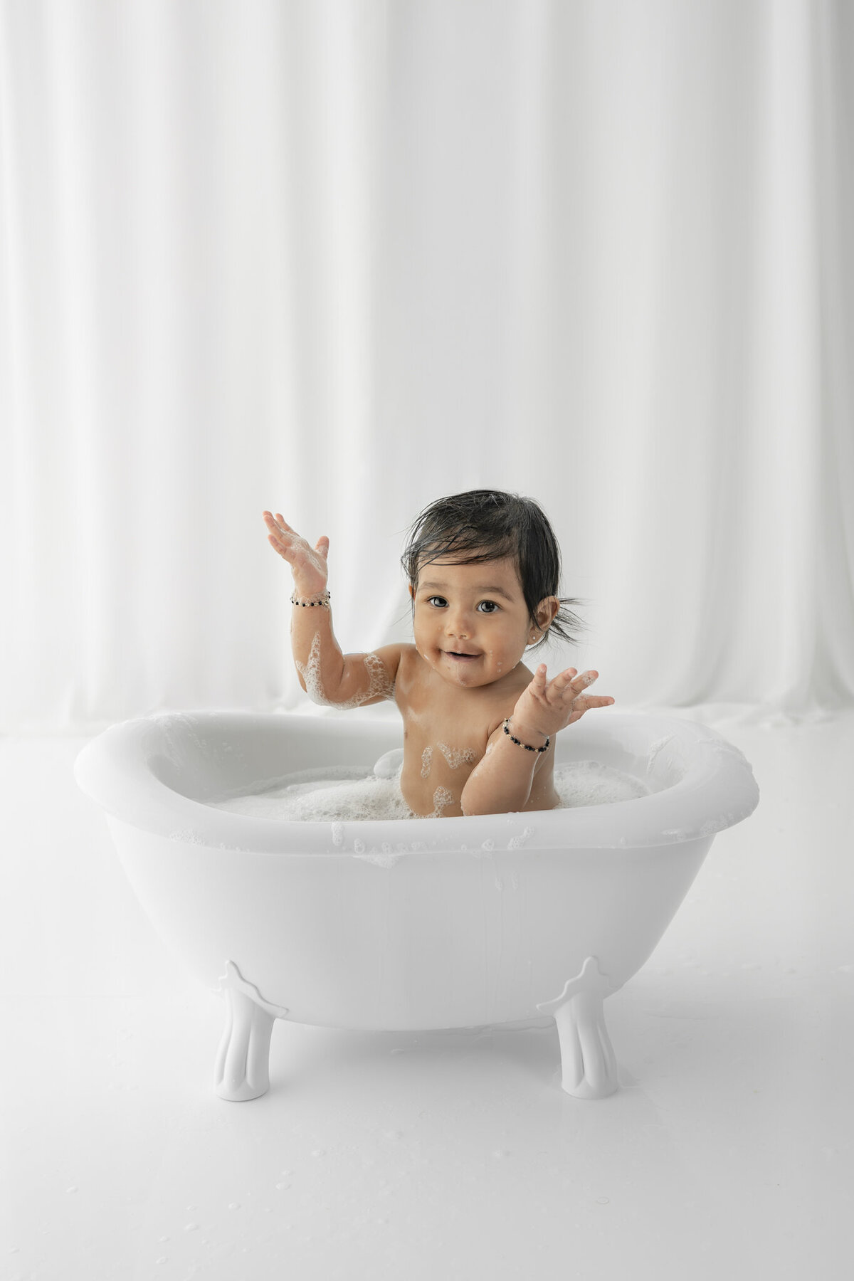 Girl in bubblebath following cake smash session— captured by Alliston and Barrie cake smash photographer.