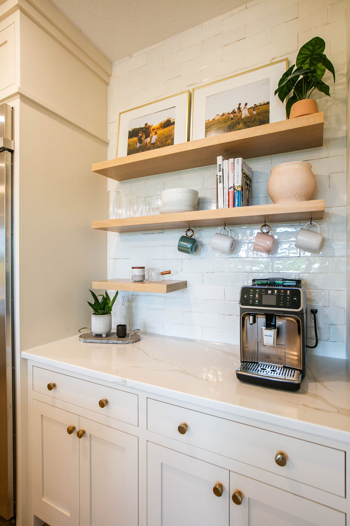 Open kitchen with white cabinets, large island, and quartz countertops in an Otsego custom home