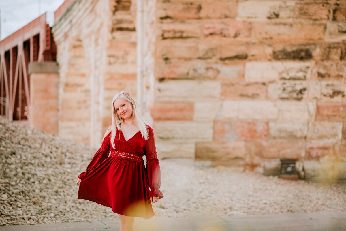 girl wearing a red dress in minneapolis near the stone arch bridge
