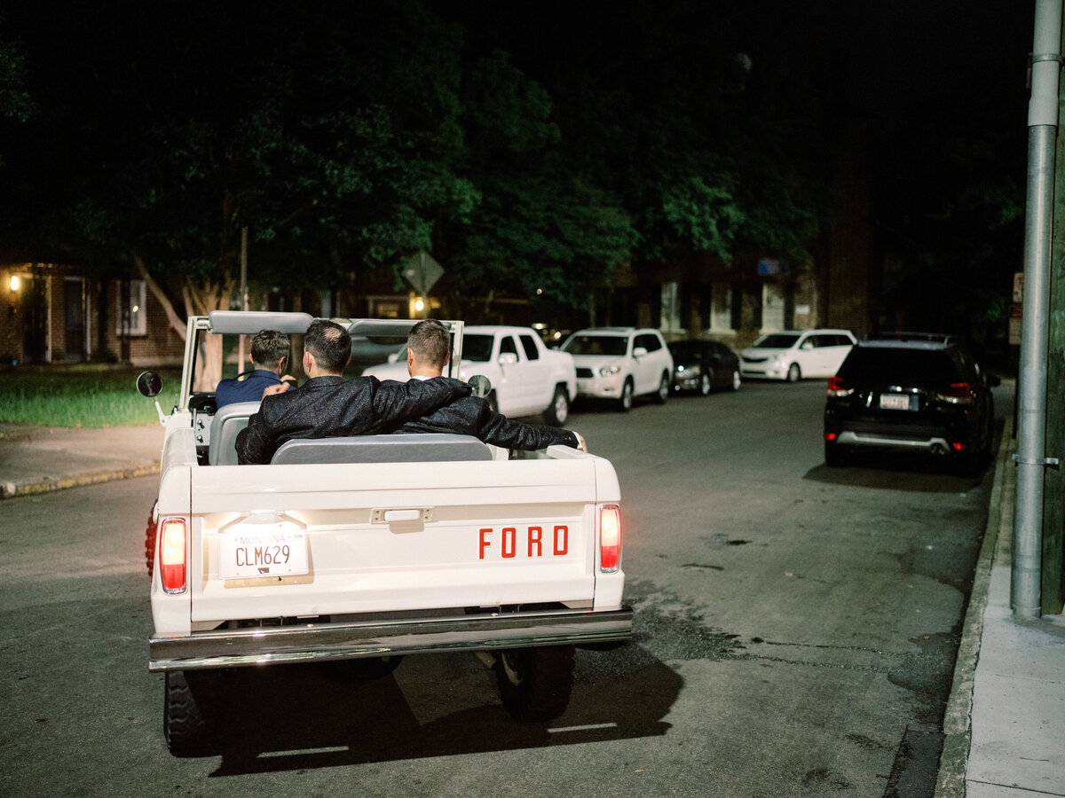 A couple enjoys a relaxing moment together in a classic vehicle after their celebration, capturing warmth and joy during their memorable night.