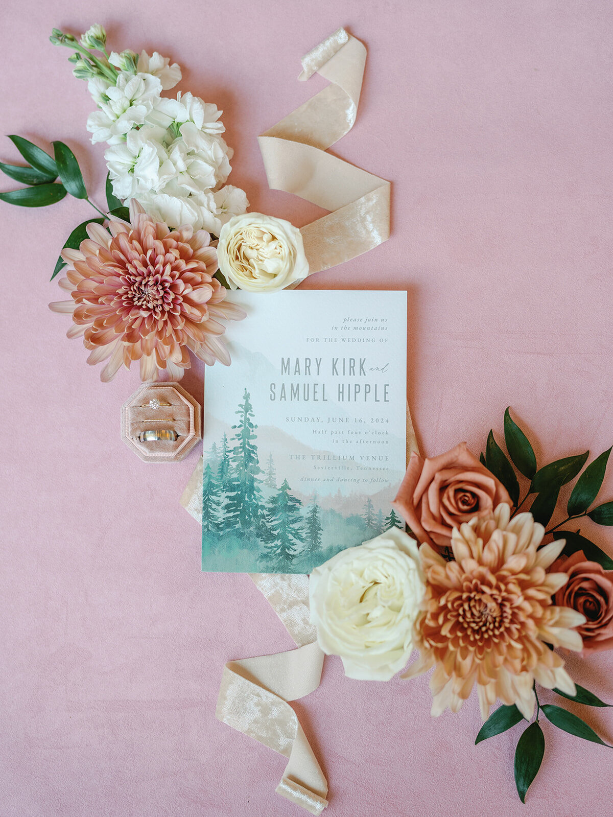 Watercolor wedding invitations laying on a blush linen