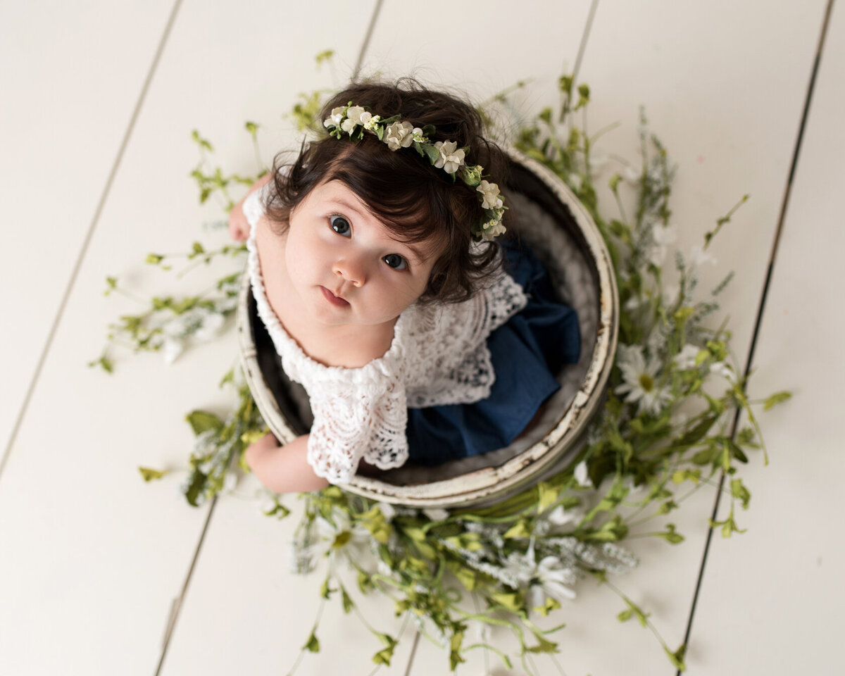 Look-up baby photo session in a flower bucket by Laura King
