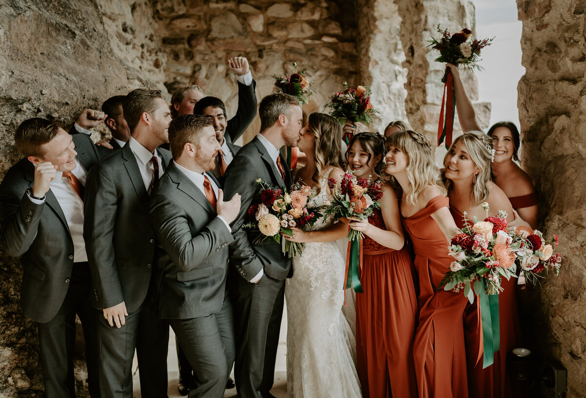 Bride and groom kiss with their bridal party at Cherokee Ranch and Castle.