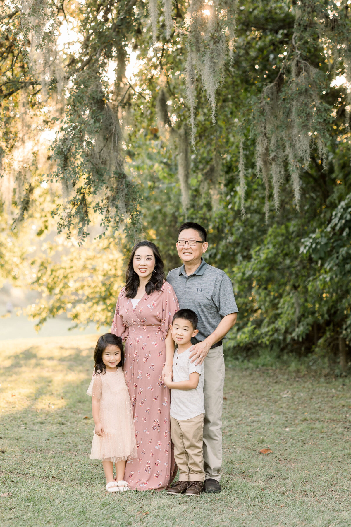 a family smiling together underneath a hanging moss tree