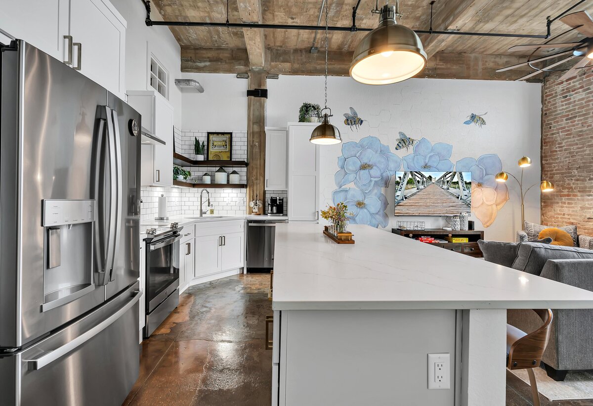 Fully stocked kitchen with island seating in this one-bedroom, one-bathroom vintage condo that sleeps 4 in the historic Behrens building in the heart of the Magnolia Silo District in downtown Waco, TX.