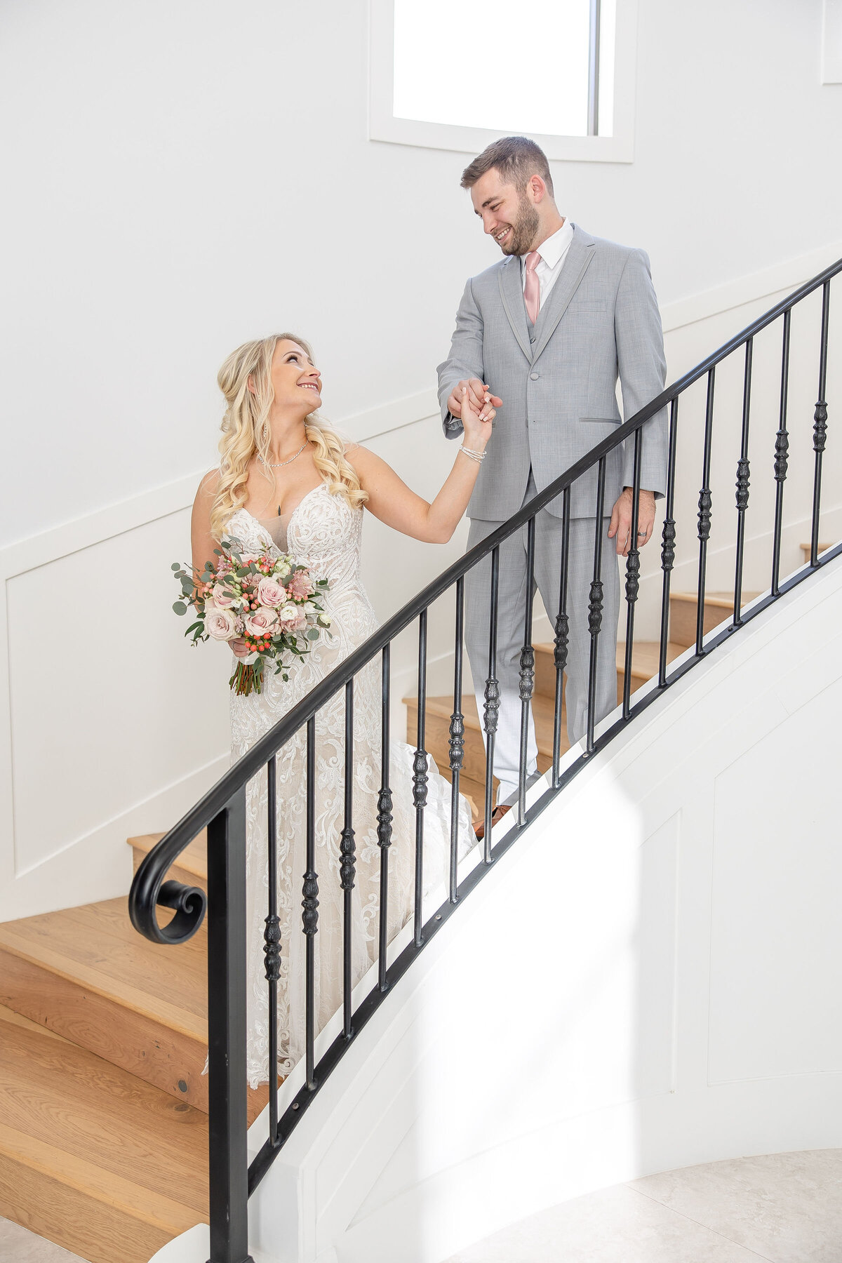 bride leads groom down spiral staircase at The Preserve at Canyon Lake wedding
