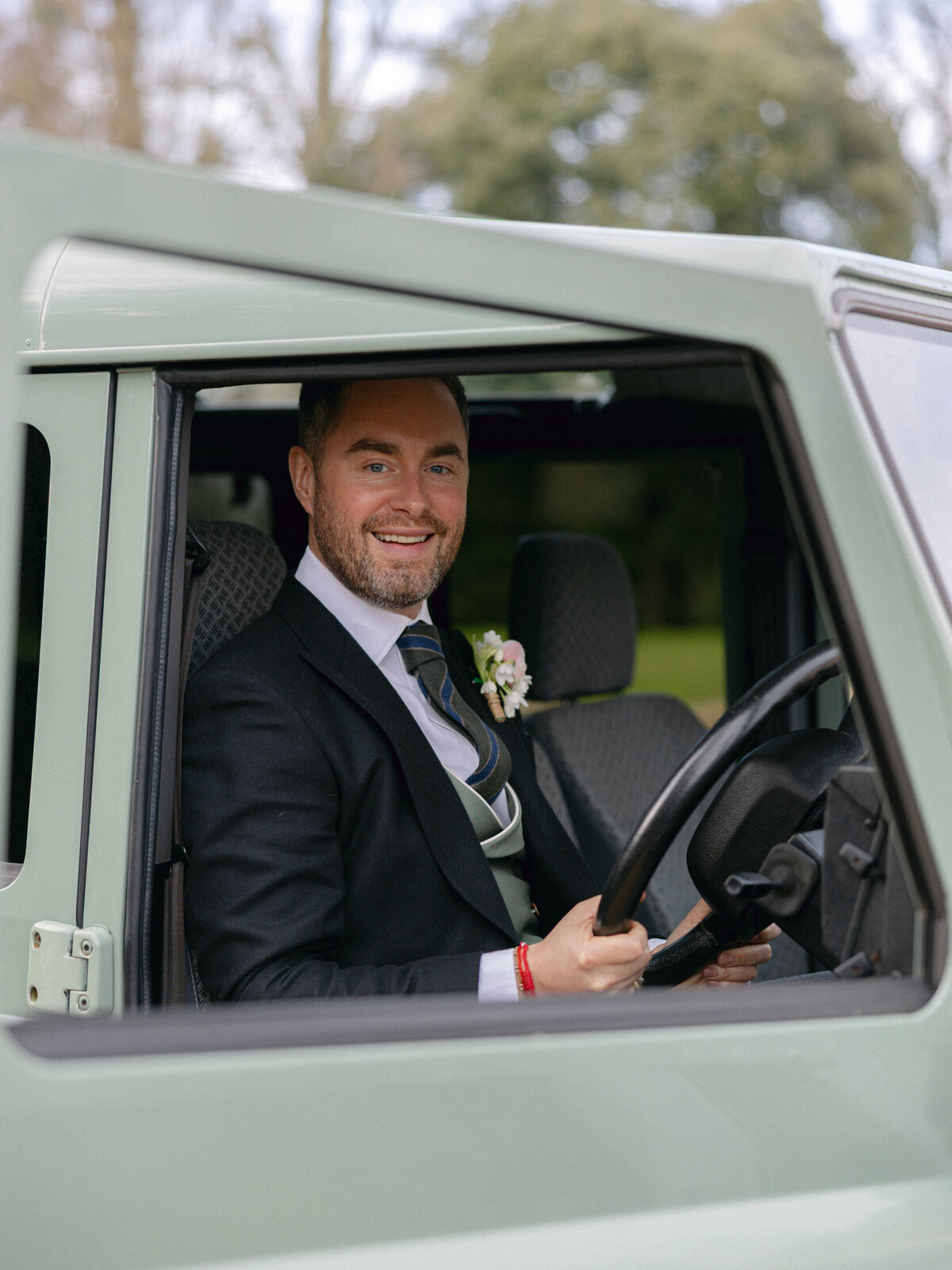 Groom driving car at wedding