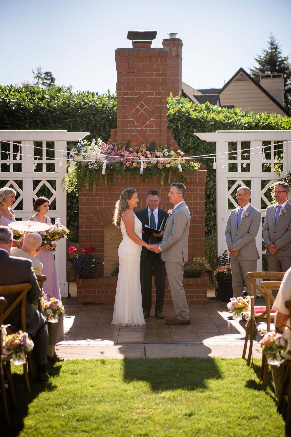 Bride and groom are framed by floral arrangements at their wedding ceremony.