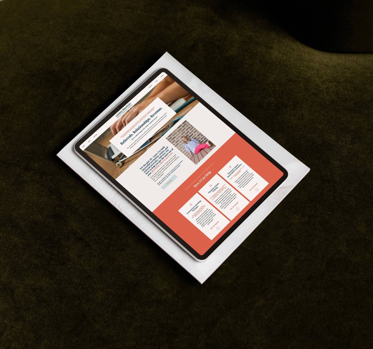 A tablet displaying a webpage with text and images, optimized through Showit website customization for personal brands, rests on top of a white envelope against a dark green surface.