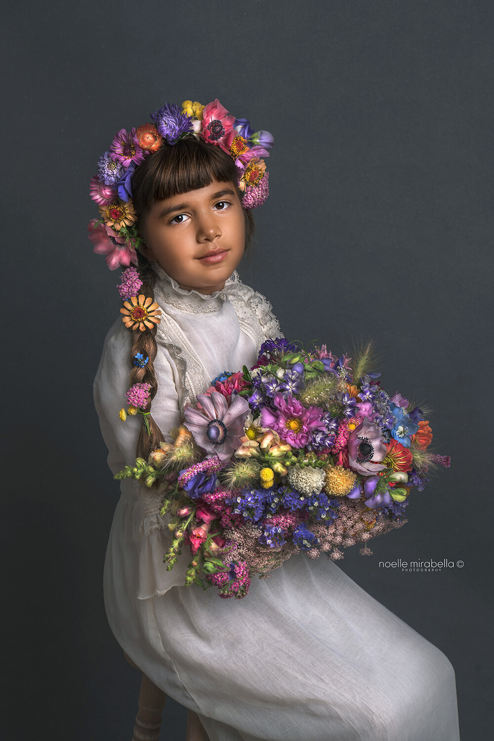 Girl holding a bouquet of multicolour flowers.